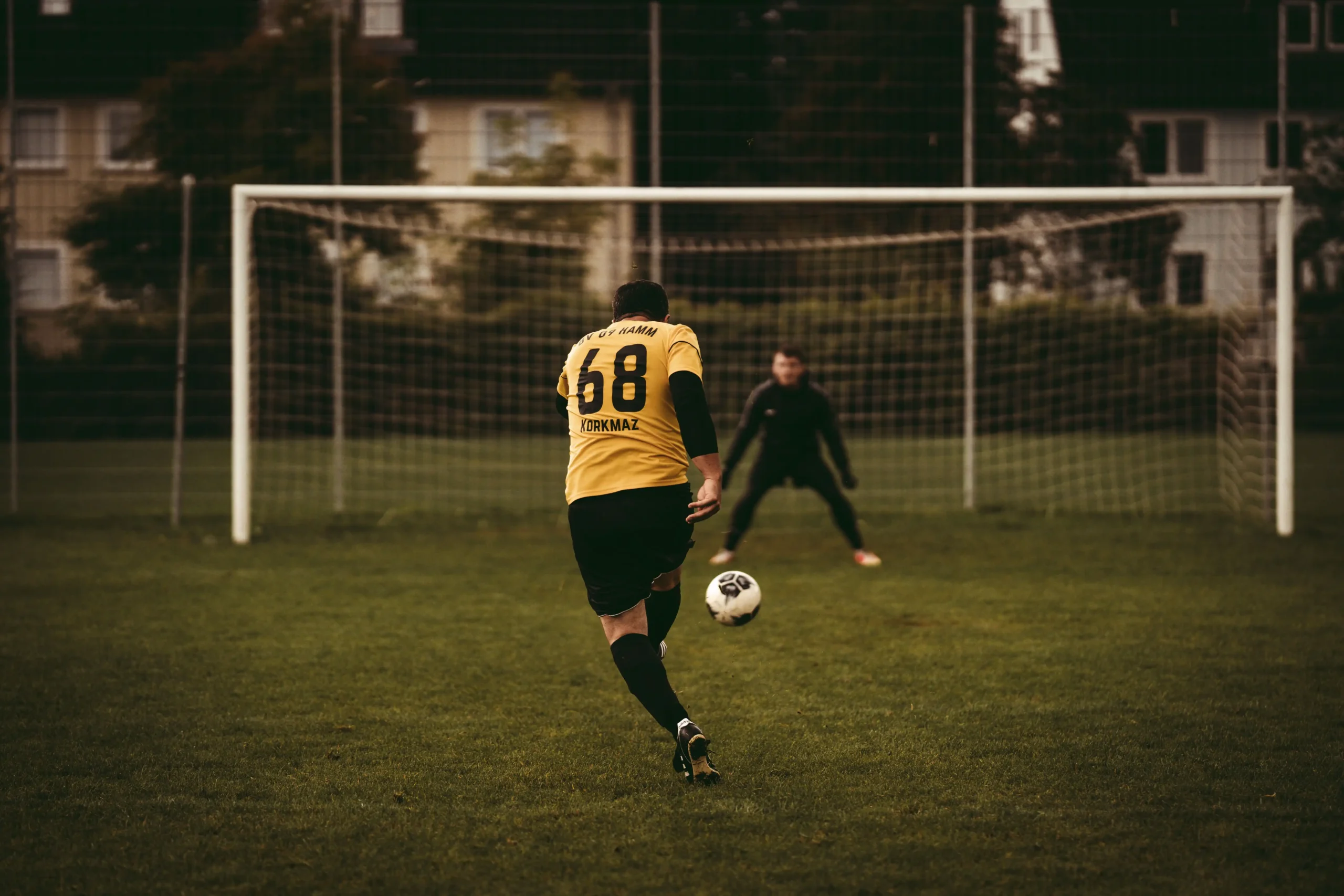 A player taking a penalty kick during a soccer match